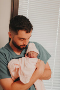 man holding newborn baby